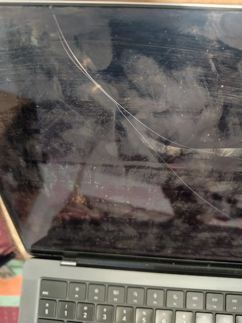Ecran de MacBook cu fisură care traversează display-ul în arc