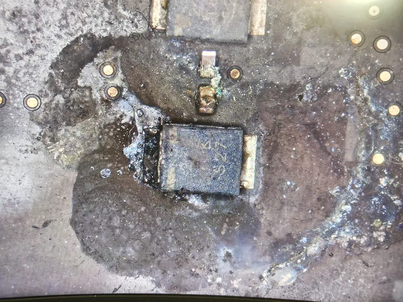 Condensator cedat violent pe linia principală de alimentare a unui MacBook Pro 14 M5 — arcul electric a carbonizat zona din jurul componentei
