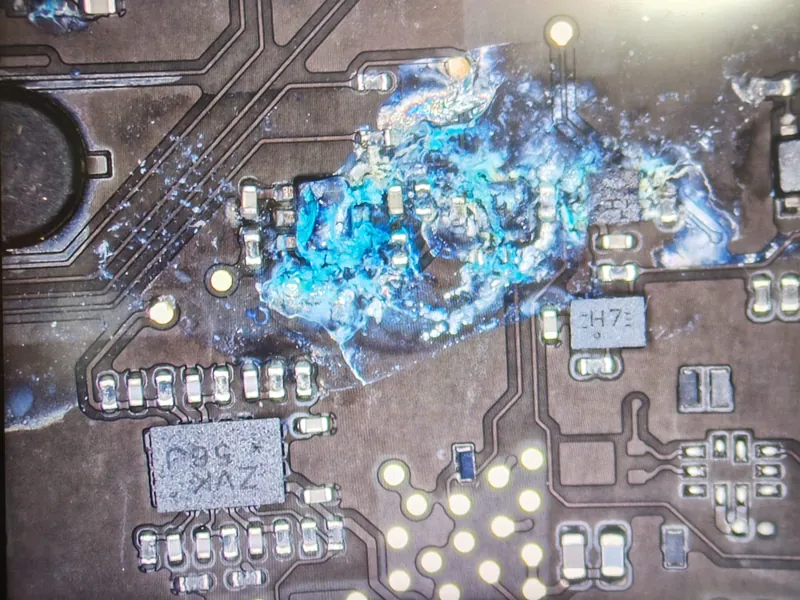Oxidare avansată a componentelor SMD pe placa de bază a unui MacBook Pro M5, văzută la microscop — service BrontoByte București
