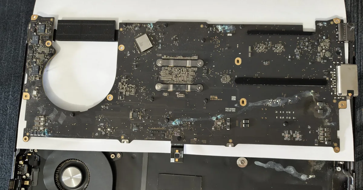 Placa de bază a unui MacBook Pro 14 M5 A3434 scoasă din carcasă, cu urme vizibile de coroziune și depuneri după contact cu lichid — service BrontoByte București