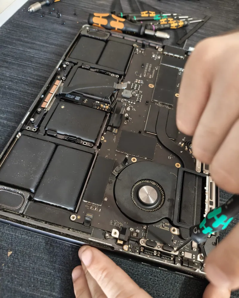 Tehnician BrontoByte reasamblează un MacBook Pro 14 M5 A3434 după repararea plăcii de bază — tastatură, trackpad și senzori verificați înainte de predare