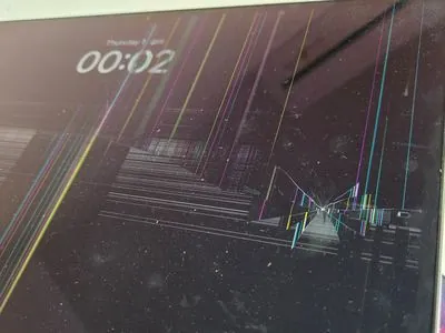 Display MacBook spart cu linii colorate și punct de impact — defect cauzat de șoc mecanic