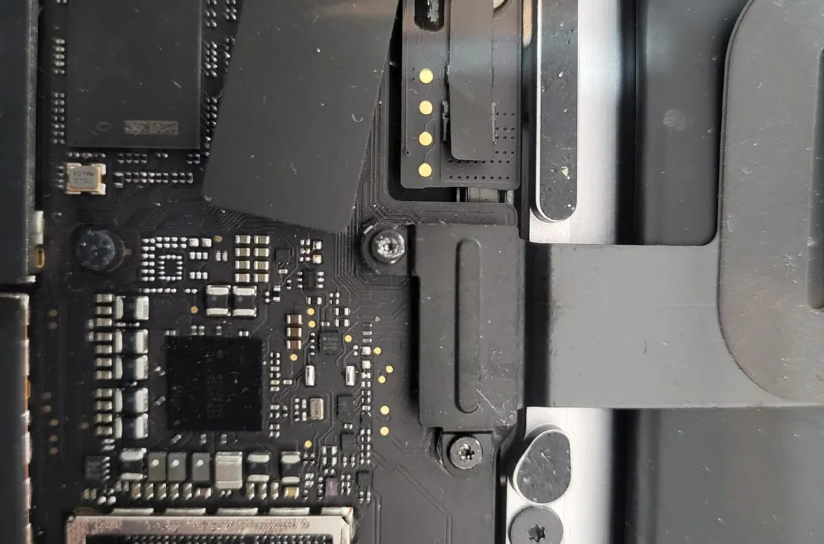 MacBook Pro deschis — chip T2 și placa de bază vizibile, rescriere EFI BrontoByte