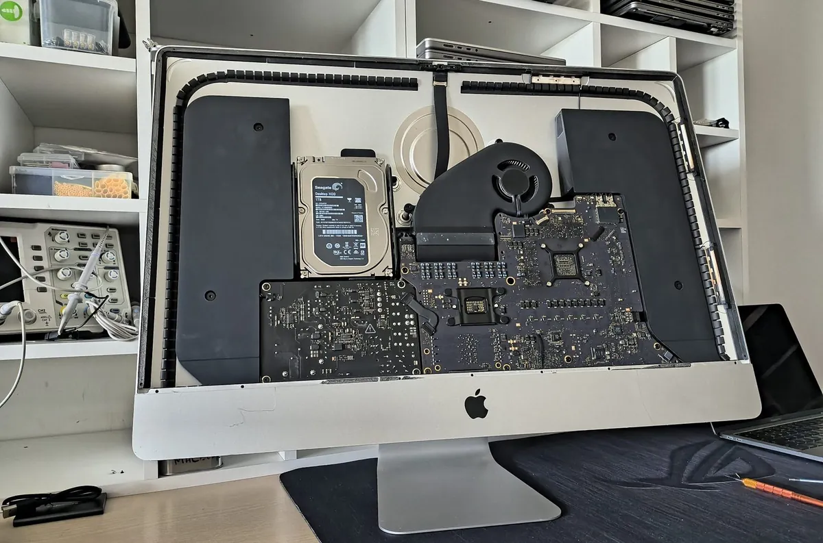 Interior iMac 27 deschis în atelierul BrontoByte din București - placă de bază, HDD și ventilator vizibile