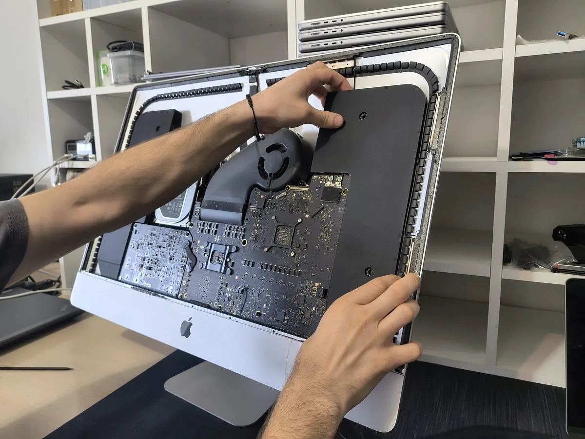 Tehniciar BrontoByte deschide display-ul iMac cu unelte profesionale specializate