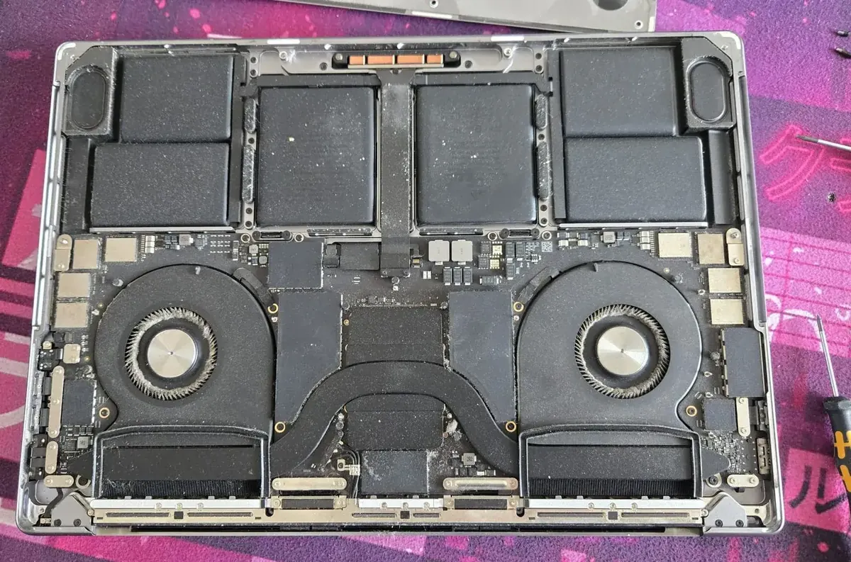 Interior MacBook Pro 16 A2485 cu praf acumulat pe ventilatoare — mentenanță MacBook București BrontoByte