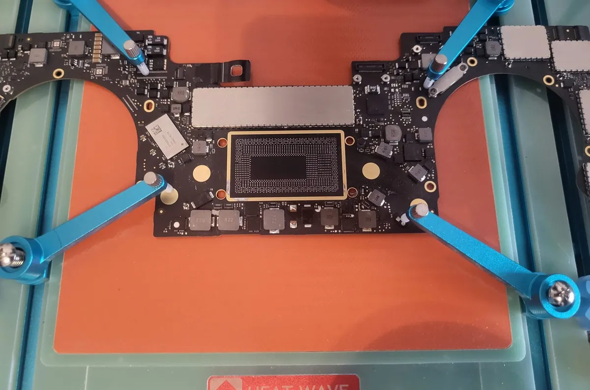 Atelier microsoldering BrontoByte cu placă de bază MacBook M-series fixată în jig HEAT WAVE pentru reparații board-level SMD/BGA