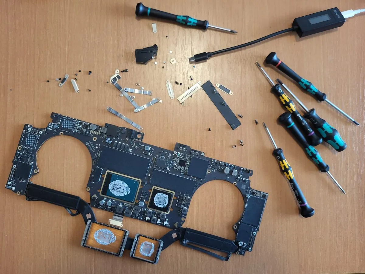 Placă de bază MacBook M-series cu CPU și SSD lipite alături de unelte profesionale Wera și tester USB-C - recuperare date