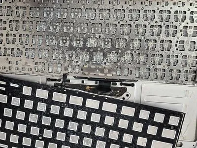 Tastatura MacBook demontata cu urme masive de lichid si coroziune vizibila sub mecanismul tastelor - defect tipic care necesita curatare profesionala si inlocuire